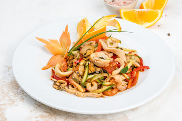 Seafood and vegetables salad served in a white plate