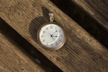 Antique pocket watch on wood. Vintage watch on wood background. Analog clock