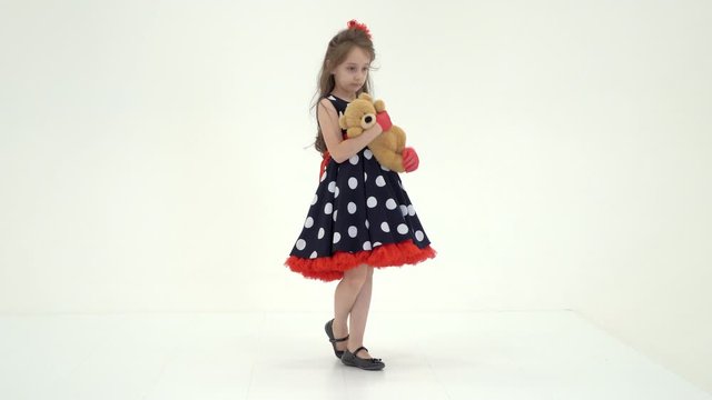 Pretty Long Haired Girl Wearing Polka Dot Dress Posing with Teddy Bear
