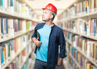 Young man wearing a blue outfit. Wearing red helmet. Looking to the side