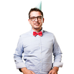 Man wearing a red bow tie and party hat. Looking bliss.