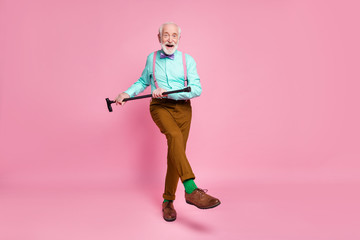 Full length photo of active grandpa moving dance pensioner party use walk stick raise leg wear mint...