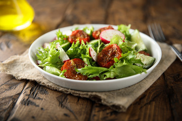 Green salad with sun dried tomatoes and radish