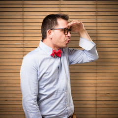 Man wearing a red bow tie. Looking surprised.