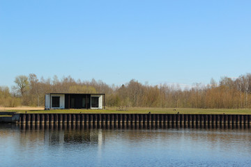 One-storey modular house that stands at the river shore. Container housing that stands aside from...