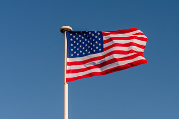 The starry flag of the United States of America (USA) on the blue sky background