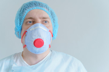 Doctor in medical disposable hat,robe,respirator.Hero tired from work, in despair from treatment of sick patients in hospital. Fighting with coronavirus covid-19.World pandemic of dangerous infection