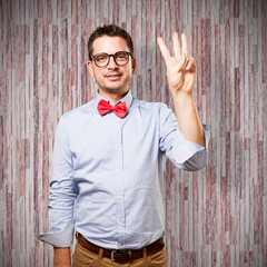Man wearing a red bow tie. Man wearing a red bow tie. Doing three number gesture. © borjandreu
