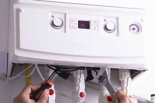 Worker repairing or service a gas heating unit