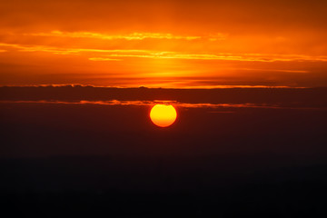 Sonnenuntergang mit großer Sonne und Wolken