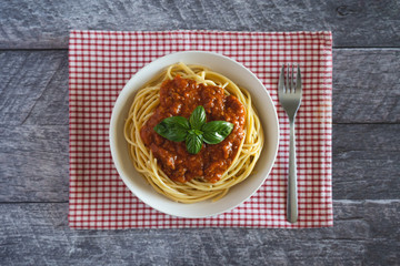 Spaghetti alla bolognese served on a wooden table.