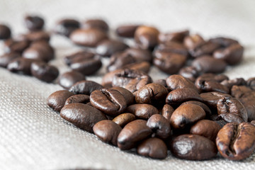 Close-up of coffee beans on linen fabric. Selective focus