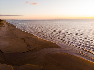 Amazing evening aerial flight along sunset beach with beautiful waves