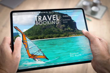 Réservation en ligne d'un hotel ou d'un voyage ou de vacances avec une tablette tenue en main par...
