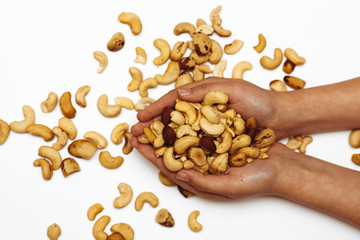 Women's hands on a white background holding fried peanuts