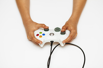 Hands of a teenager on a white background holding a joystick from a game console