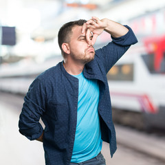 Young man wearing a blue outfit.Stinky gesture.