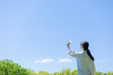 手作りの紙飛行機を持つ若い女性女性