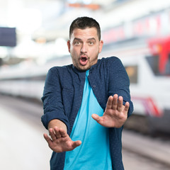 Young man wearing a blue outfit. looking afraid.