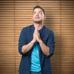 Young man wearing a blue outfit. Look praying.