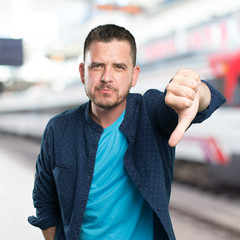 Young man wearing a blue outfit. With the thumb down.