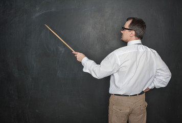 Teacher man retro style with pointer standing back to blackboard
