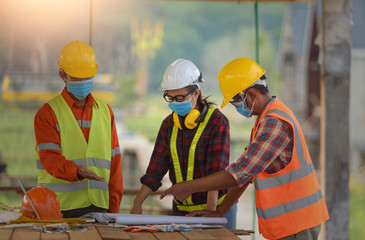 female inspectors and architects discuss with head engineer about construction project.Multi-ethnic group of engineers meeting at construction site in eveing time