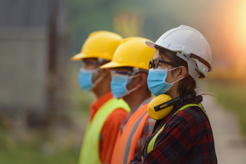 Fototapeta premium Corona or Covid-19 wear masks during the design of construction. New normal.Industrial engineering team wears a COVID 19 protective mask. Workers wear a quarantine face mask.
