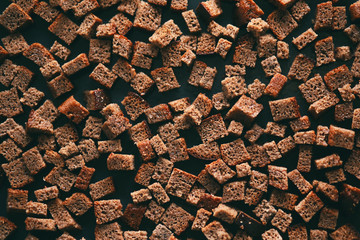 Cut into cubes, rye bread is placed on a dark baking sheet,  it is sent to the oven and it will...