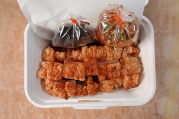 traditional Thai culture air fryer fried pork cuisine style or moo tod krob favorite famous street fast foods menu at thailand homemade
with hot spicy sauces on table wood dish sticky rice vegetable