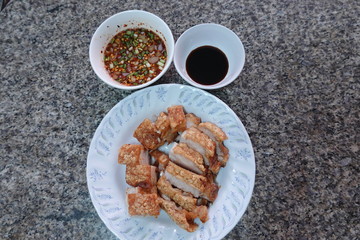traditional Thai culture air fryer fried pork cuisine style or moo tod krob favorite famous street fast foods menu at thailand homemade
with hot spicy sauces on table wood dish sticky rice vegetable