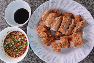 traditional Thai culture air fryer fried pork cuisine style or moo tod krob favorite famous street fast foods menu at thailand homemade
with hot spicy sauces on table wood dish sticky rice vegetable