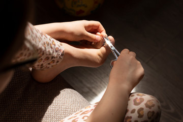 Pedicure beauty at home. Cares foot nails. Foot fingernails cutting with scissors.