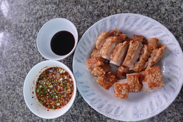 traditional Thai culture air fryer fried pork cuisine style or moo tod krob favorite famous street fast foods menu at thailand homemade
with hot spicy sauces on table wood dish sticky rice vegetable