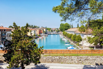 View from the pedestrian bridge to the Minsio river, which flows into the garda lake with mooring boats. Peschiera del Garda, Italy, Garda lake 