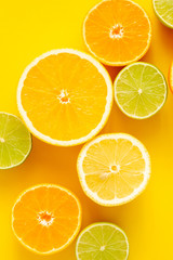 Citrus fruits pattern background, grapefruit, orange, tangerine, lemon, lime on yellow background. Flat lay, top view, copy space