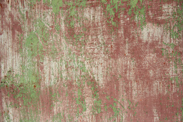 grunge burgundy wall with green and scratches..background rusty wall spliced with corrosion