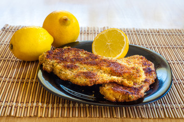 Crispy breaded chicken breasts with lemon