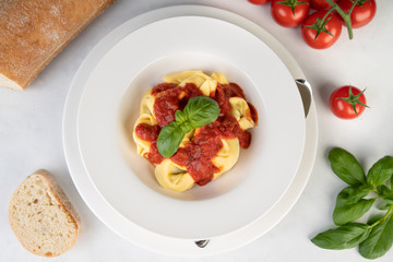 Frische Tortelini mit Tomatensoße und Basilikum von oben