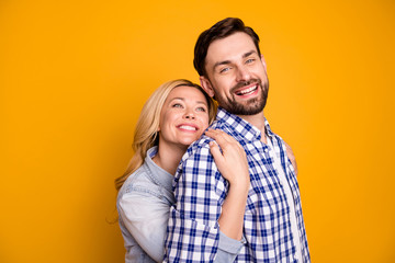 Photo beautiful wife lady handsome husband guy couple hug his strong back feel safety good mood in love perfect pair hold arms wear casual shirts clothes isolated yellow color background
