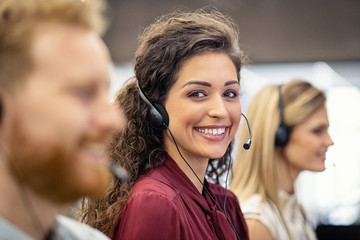Portrait of smiling woman working in call center - obrazy, fototapety, plakaty