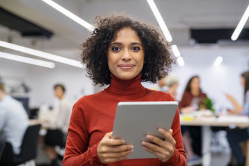 Mixed race young woman using digital tablet - Powered by Adobe