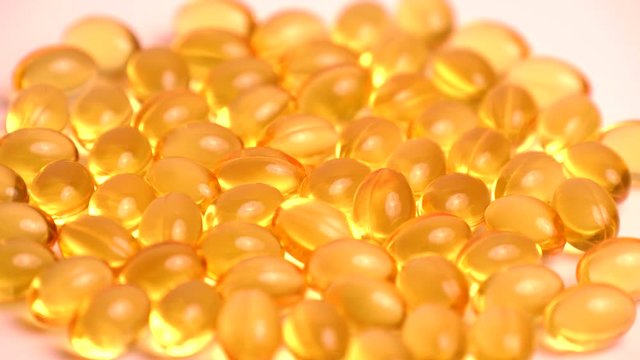 Golden background capsules Close up food supplement oil filled capsules suitable vitamin A, vitamin D3, fish oil, omega 3, 6, 9, evening primrose, borage oil, flax seeds oil, vitamin D, vitamin E