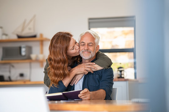 Woman in love kissing senior man on cheeck
