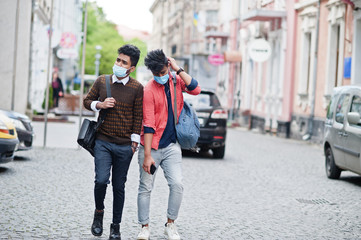 Coronavirus covid-19 concept. Two south asian indian man wearing mask for protect from corona virus walking at city. New normal lifestyle post pandemic in India.