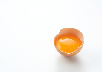 A broken egg placed on a white background with copy space