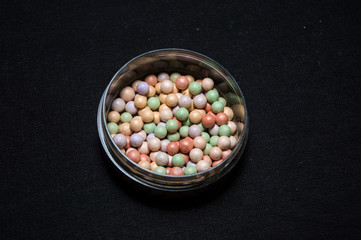 beauty powder balls and brush on black background 