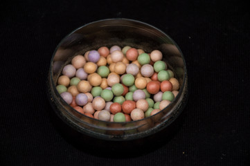 beauty powder balls and brush on black background 