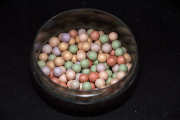 beauty powder balls and brush on black background 