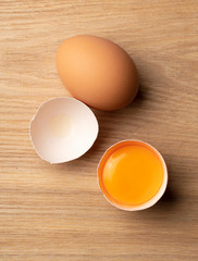 Eggs and broken eggs on a wooden table.